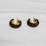 A pair of small gold-tone hoop earrings encrusted with sparkling rhinestones