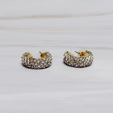 A pair of small gold-tone hoop earrings encrusted with sparkling rhinestones