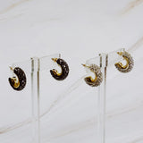 A pair of small gold-tone hoop earrings encrusted with sparkling rhinestones