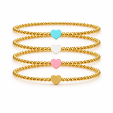 Gold beaded bracelet with heart-shaped charms on a white background