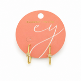 Gold earrings on a pink card with 'Ellison + Young' branding.