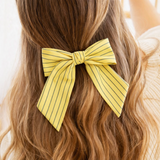 Striped ribbon bow hair clips in pastel pink with green stripes and soft yellow with blue stripes. The Striped Ribbon Bow Hair Clip – Classic Preppy Style adds a charming, polished accent to any hairstyle, blending playful color with timeless sophistication.