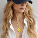 Gold necklace featuring two radiant sunburst medallions accented with sparkling crystals. The Sunbeam Medallion Necklace showcases a modern vintage glow with layered coin charms and a sleek link chain for timeless sophistication.