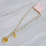 Gold necklace featuring two radiant sunburst medallions accented with sparkling crystals. The Sunbeam Medallion Necklace showcases a modern vintage glow with layered coin charms and a sleek link chain for timeless sophistication.