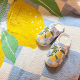 Soft indoor slippers featuring a bright lemon pattern on a checkered background, with a round-toe design, available in multiple sizes