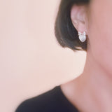 Set of two pearl earrings featuring playful sunny-side-up egg and classic pearl designs, combining whimsy with elegance.