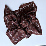 Lightweight textured square scarf with a soft finish, ideal for accessorizing hair, necklines, or handbags with effortless elegance.