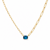 Gold necklace with a blue gemstone on a white background