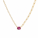 Gold chain necklace with a pink gemstone on a white background