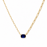 Gold chain necklace with a blue gemstone on a white background