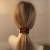 Stylish hair tie featuring a glossy tortoise-shell dome accent—perfect for adding a chic, polished touch to ponytails or buns.
