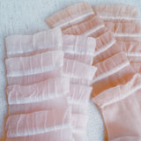 Set of two socks adorned with cascading tulle lace detailing, adding a soft, romantic flair to any look.