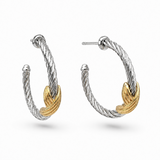 A pair of silver-toned cable-knit hoop earrings with a gold-toned leaf accent on each earring, shown against a plain white background.