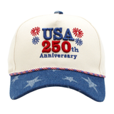 Cream baseball cap featuring “USA 250th Anniversary” embroidery with red and blue firework accents and a blue star-print brim for a patriotic Americana look.