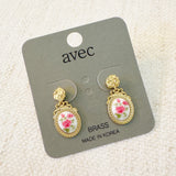 Gold-tone vintage-style drop earrings featuring an oval cameo with delicate pink rose floral design and ornate top stud