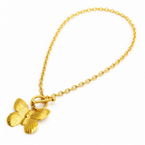 Gold butterfly pendant on a gold chain against a white background