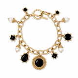 A gold-tone charm bracelet with a toggle clasp, featuring black onyx and pearl charms, set against a plain white background.
