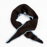 A dark brown knit scarf with a light blue textured edge, arranged in a loop on a plain white background.