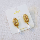 Gold oval stud earrings featuring a detailed cross design and dangling teardrop pearls—blending vintage charm with timeless elegance.