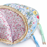 Quilted cosmetic case featuring a vintage-inspired floral print with soft padding and a structured shape, designed for storing makeup and small essentials.