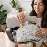 Woman holding a floral makeup bag with dimensions labeled, surrounded by plants and a laptop.