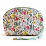 Quilted cosmetic case featuring a vintage-inspired floral print with soft padding and a structured shape, designed for storing makeup and small essentials.