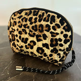 Quilted cosmetic case with a vintage-inspired leopard print design, featuring a soft padded texture and zip closure for stylish and functional storage.