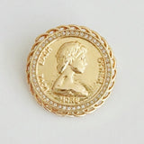 Round vintage-style brooch pin featuring a raised gold-tone medallion design of a classical female profile, bordered with beaded detailing and antique finish for an old-world charm.