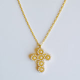 Elegant vintage-inspired necklace featuring a delicate cross pendant adorned with lustrous pearls and intricate detailing. Suspended from a fine chain, this piece blends timeless charm with a touch of sophistication—ideal for both faith-inspired style and classic fashion statements.