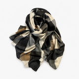 A lightweight square scarf with a large-scale checkered pattern in black, beige, gray, and brown, draped elegantly on a light gray background.