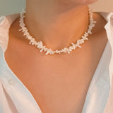 Elegant necklace featuring natural stone beads in coral-inspired shapes, available in two variants—deep red and soft white—each evoking the beauty of coastal reefs with a touch of organic charm.