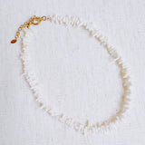 Elegant necklace featuring natural stone beads in coral-inspired shapes, available in two variants—deep red and soft white—each evoking the beauty of coastal reefs with a touch of organic charm.