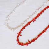 Elegant necklace featuring natural stone beads in coral-inspired shapes, available in two variants—deep red and soft white—each evoking the beauty of coastal reefs with a touch of organic charm.