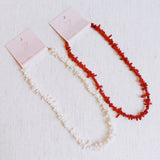 Elegant necklace featuring natural stone beads in coral-inspired shapes, available in two variants—deep red and soft white—each evoking the beauty of coastal reefs with a touch of organic charm.