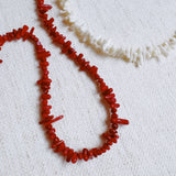 Elegant necklace featuring natural stone beads in coral-inspired shapes, available in two variants—deep red and soft white—each evoking the beauty of coastal reefs with a touch of organic charm.