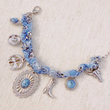 Scarf-wrapped bracelet featuring gold and sliver-tone Western-themed charms including a cowboy boot, sunburst, and lasso motifs
