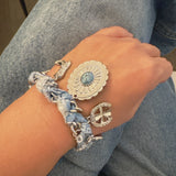 Scarf-wrapped bracelet featuring gold and sliver-tone Western-themed charms including a cowboy boot, sunburst, and lasso motifs