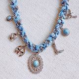 Chain necklace woven with printed scarf fabric, adorned with Western-themed charms including a boot, sunburst, and sheriff star.