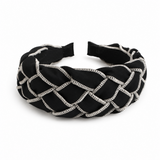 Black headband with crisscross pattern on a white background