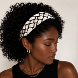 Woman wearing a black and white patterned headband with a neutral background