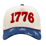 Cream and navy baseball cap featuring bold “1776” embroidery on the front with a blue brim detailed in white stars for a patriotic Americana look.