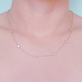 Delicate gold-tone necklace featuring twelve evenly spaced bezel-set sparkling stones along a fine chain, offering a dainty and radiant look