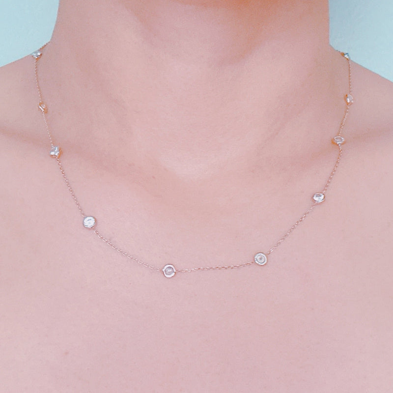 Delicate gold-tone necklace featuring twelve evenly spaced bezel-set sparkling stones along a fine chain, offering a dainty and radiant look