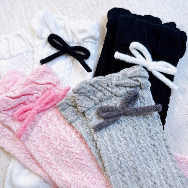 Set of two cozy socks featuring soft yarn bow accents, combining comfort with a touch of playful charm.