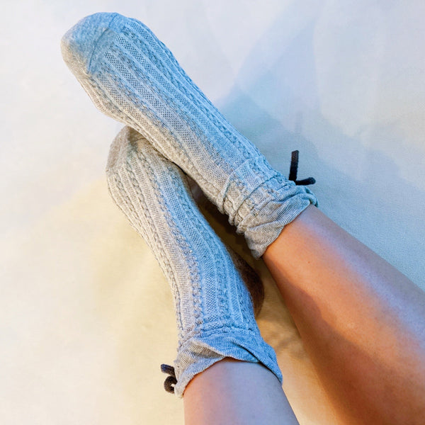 Set of two cozy socks featuring soft yarn bow accents, combining comfort with a touch of playful charm.