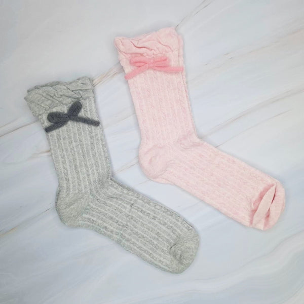 Cozy and cute set of two pairs of socks, each featuring soft yarn bows on the sides—perfect for adding a sweet and playful touch to everyday outfits.