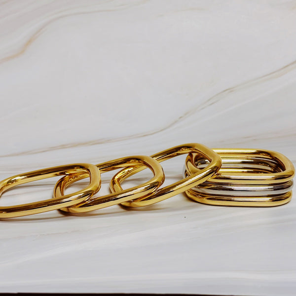 Two sets of square-shaped stacking bangles—one in solid gold-tone and one in a mixed gold and silver finish