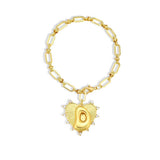Gold bracelet with a heart-shaped charm on a white background