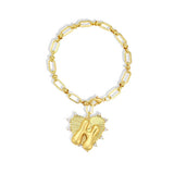 Gold bracelet with a heart-shaped charm featuring the letter 'H' on a white background