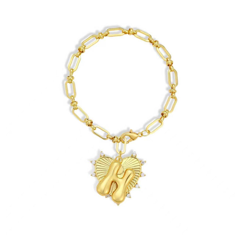 Gold bracelet with a heart-shaped charm featuring the letter 'H' on a white background